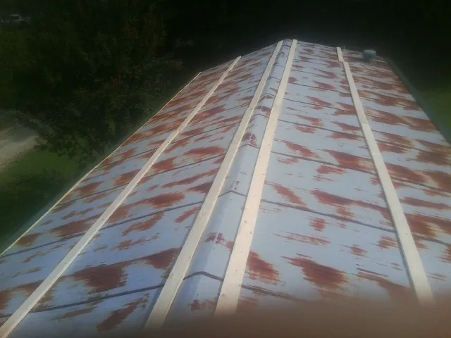 Rusted metal roof panels with new wood purlins before replacement — Storm Damage Roof Repair in Newport by Roofing Brothers
